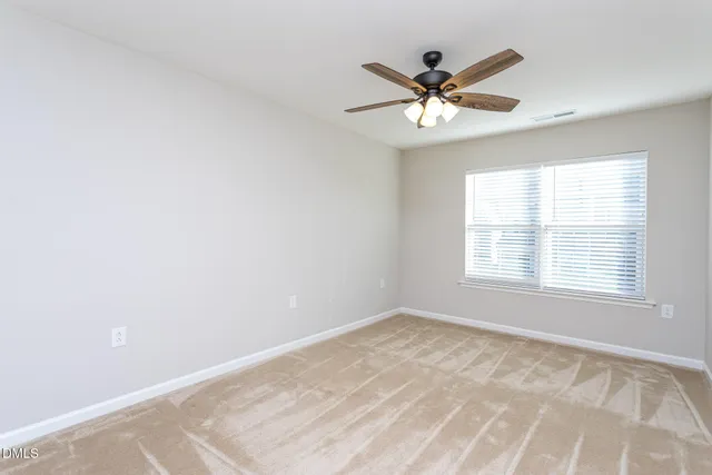 a view of a livingroom with a ceiling fan and window