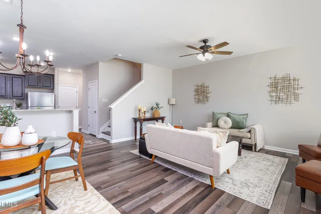 a living room with furniture a chandelier and a dining room