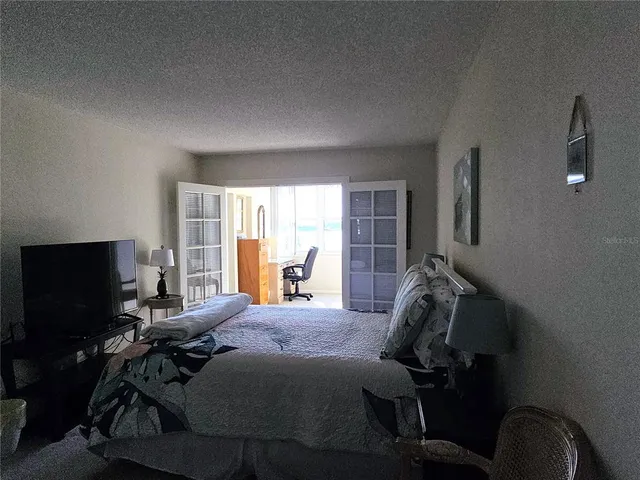 a bedroom with a bed and a lamp on dresser