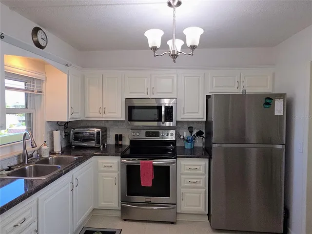 a kitchen with refrigerator a microwave a stove and cabinets
