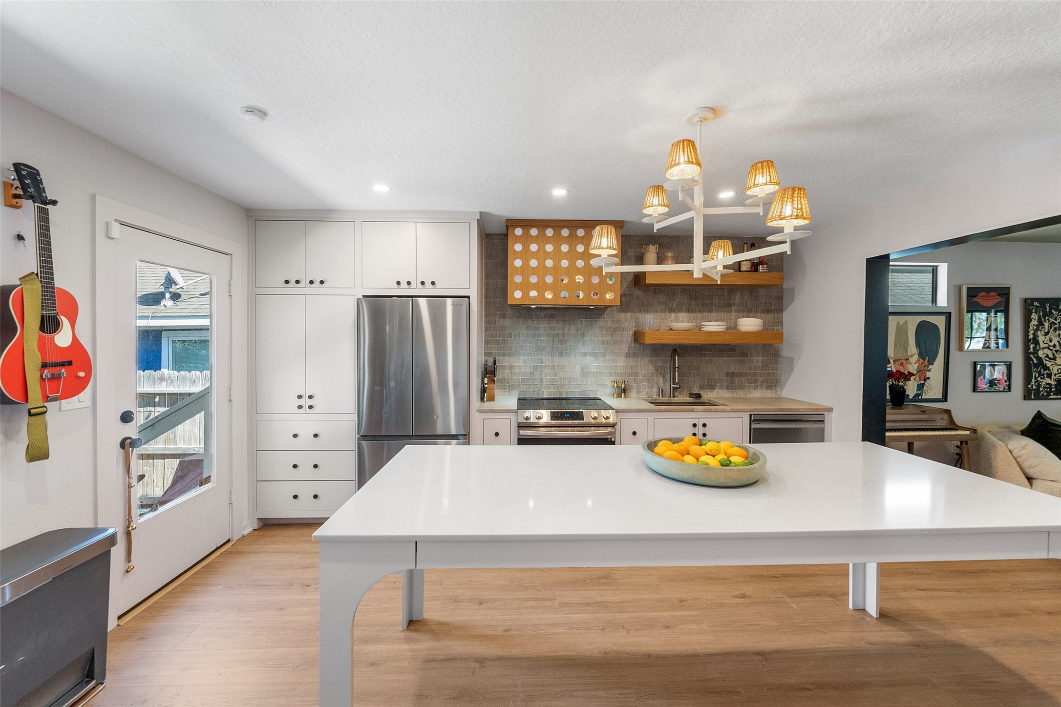 805 East 36th Street Houston, TX 77022 - Photo 12 of 28 a kitchen with a refrigerator a stove and a wooden floor