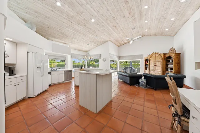 a kitchen with stainless steel appliances kitchen island granite countertop a refrigerator and a sink