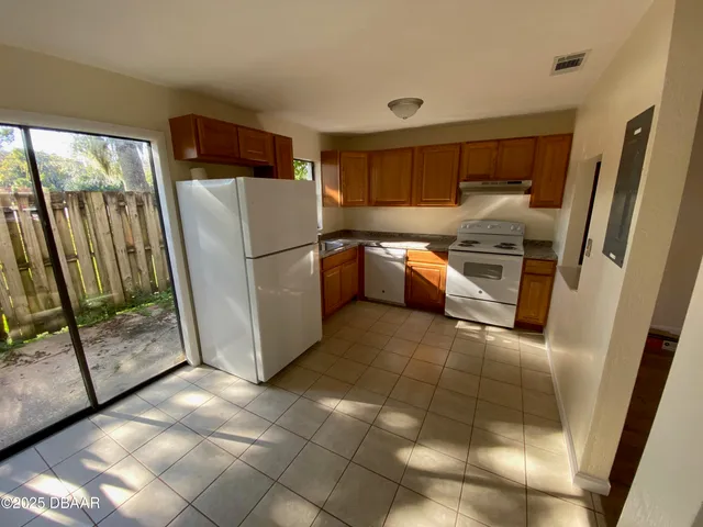 a kitchen with a refrigerator and white cabinets