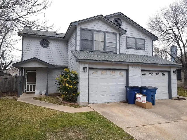 a living room with a fireplace furniture a ceiling fan and a window
