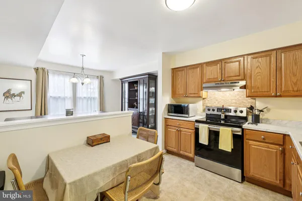 a kitchen with a stove a sink cabinetry and a refrigerator