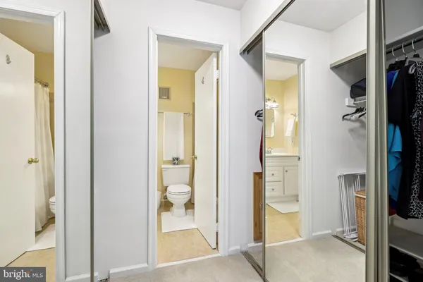 a bathroom with a granite countertop sink mirror and a toilet