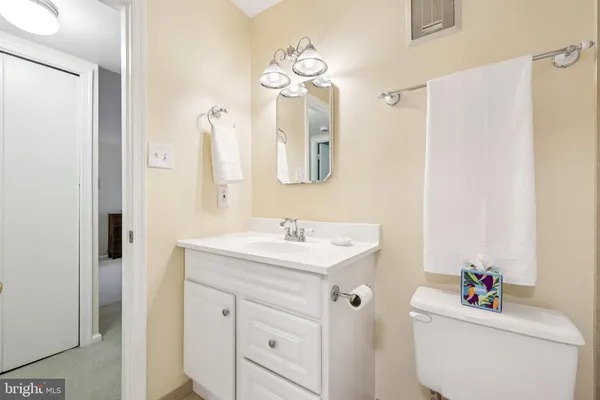 a bathroom with a sink vanity mirror and toilet