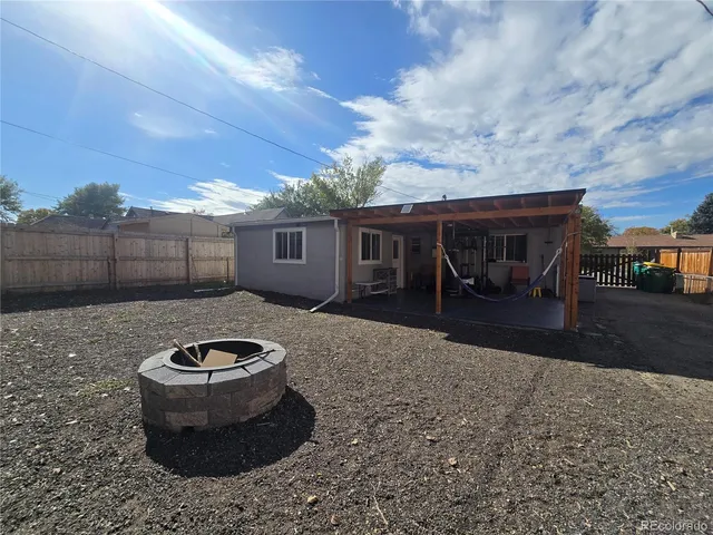 a view of a backyard with table and chairs with wooden fence