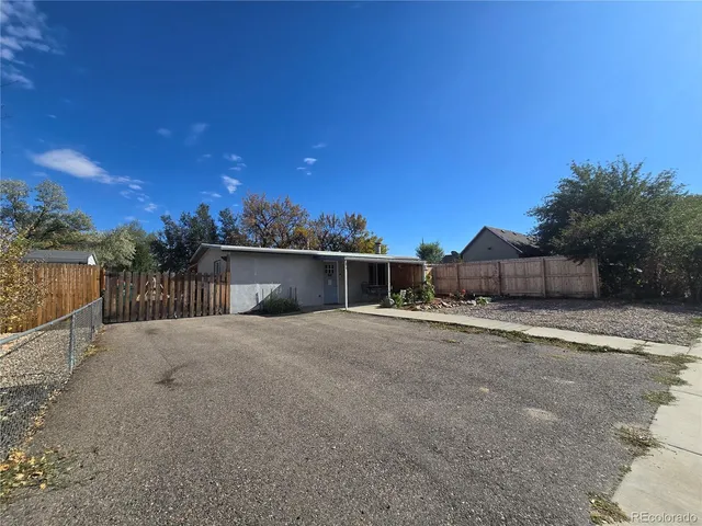 a view of a house with a yard and wooden fence