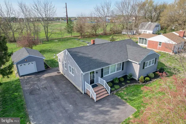 a aerial view of a house next to a big yard and large trees