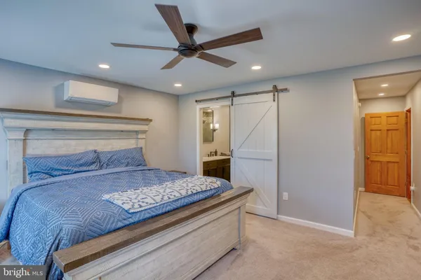 a bedroom with a large bed and a ceiling fan