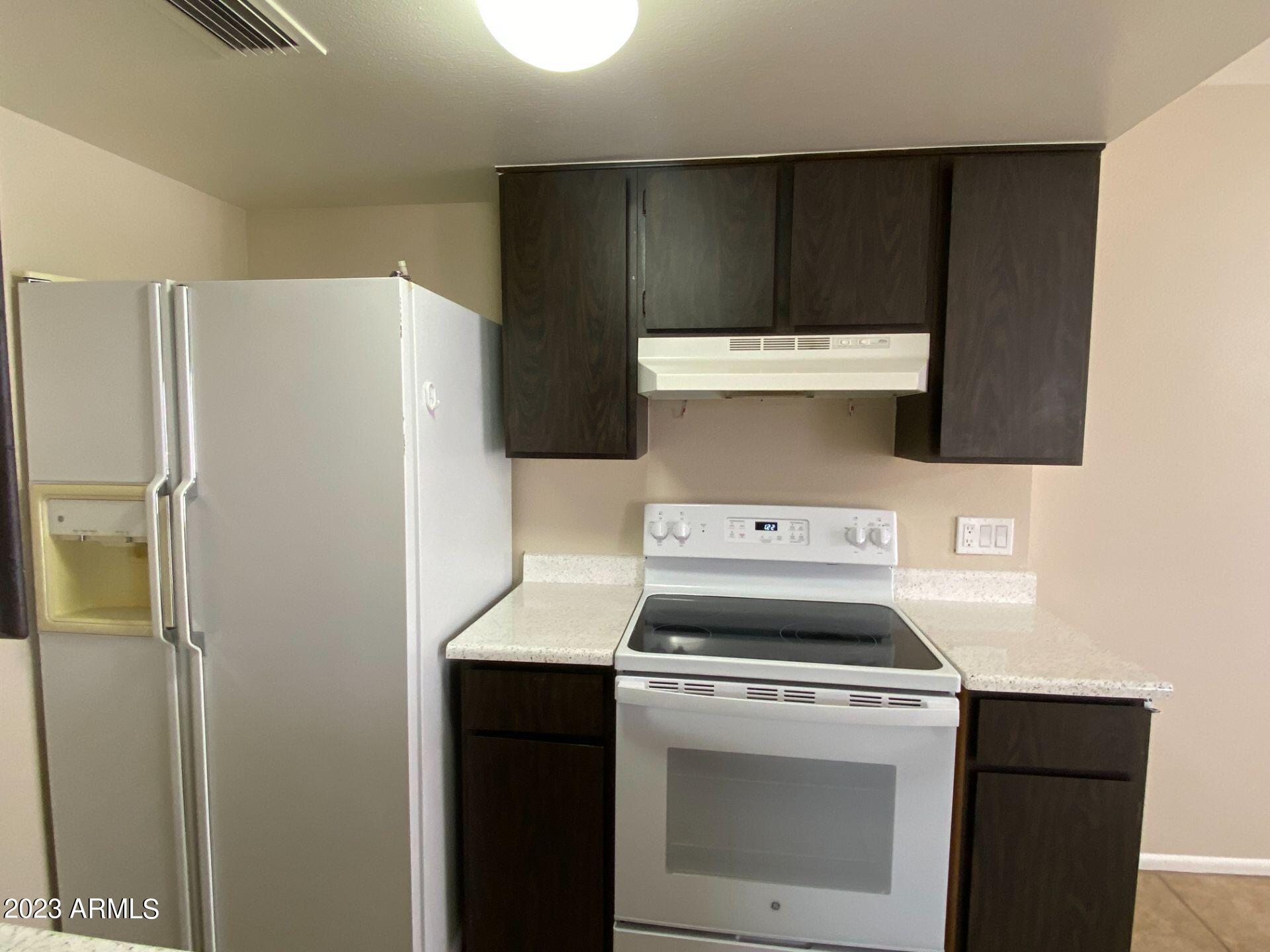 17024 East Calle Del Oro, Unit B Fountain Hills, AZ 85268 - Photo 7 of 22 a kitchen with a stove and a refrigerator