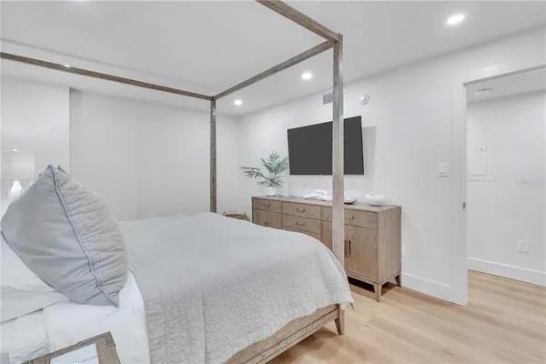 a bedroom with a bed and a flat screen tv