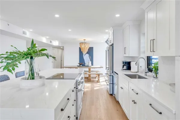 a large white kitchen with lots of counter space and a sink