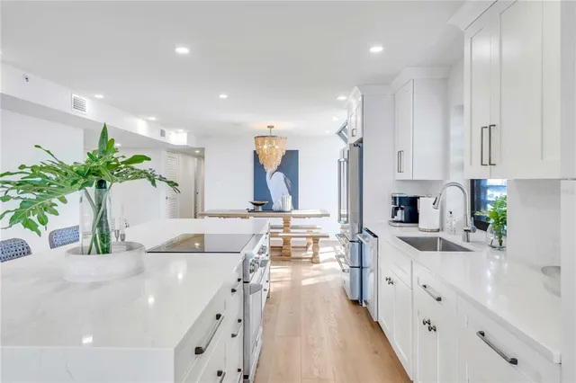 a large white kitchen with lots of counter space and a sink