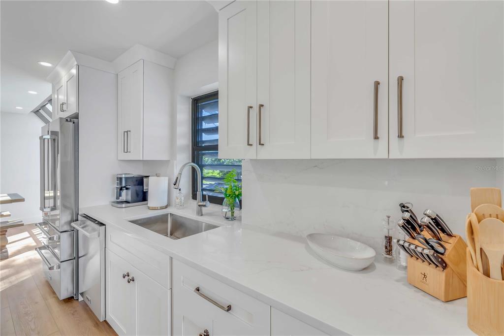 5611 Gulf Of Mexico Drive, Unit 1 Longboat Key, FL 34228 - Photo 19 of 39 a kitchen with stainless steel appliances granite countertop a sink a stove and white cabinets