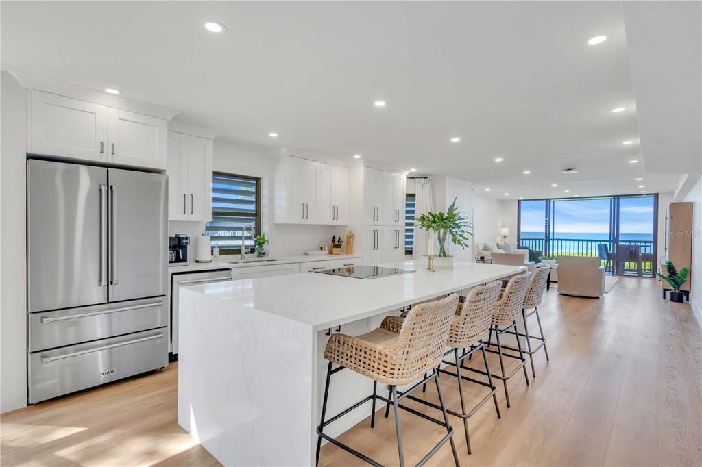 5611 Gulf Of Mexico Drive, Unit 1 Longboat Key, FL 34228 - Photo 21 of 39 a kitchen with stainless steel appliances a dining table chairs refrigerator and sink