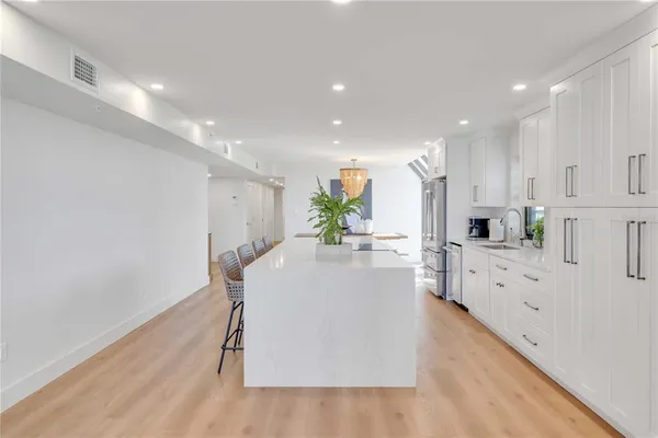 a kitchen with stainless steel appliances kitchen island granite countertop a refrigerator and a stove top oven