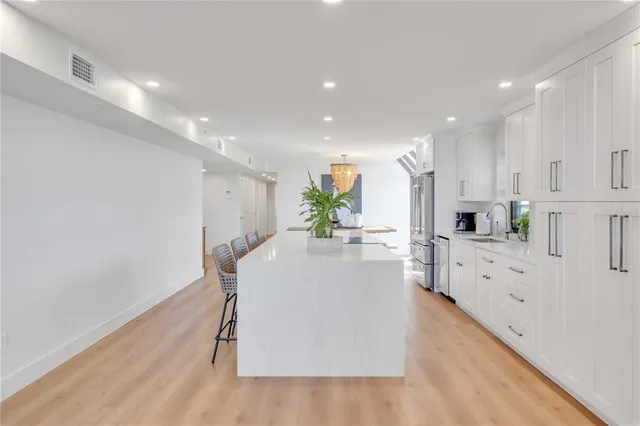 a kitchen with stainless steel appliances kitchen island granite countertop a refrigerator and a stove top oven