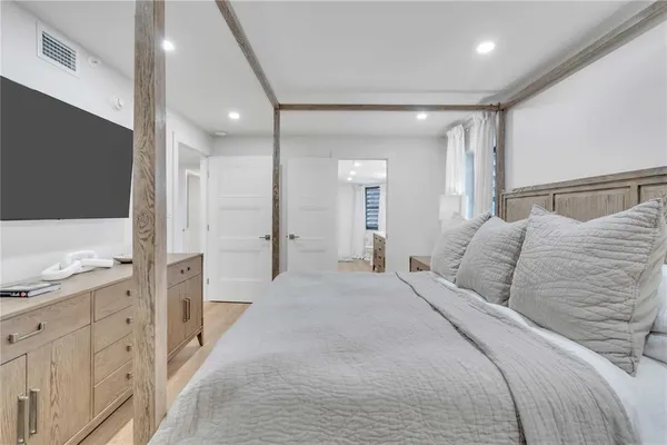 a large bedroom with a large bed and wooden floors