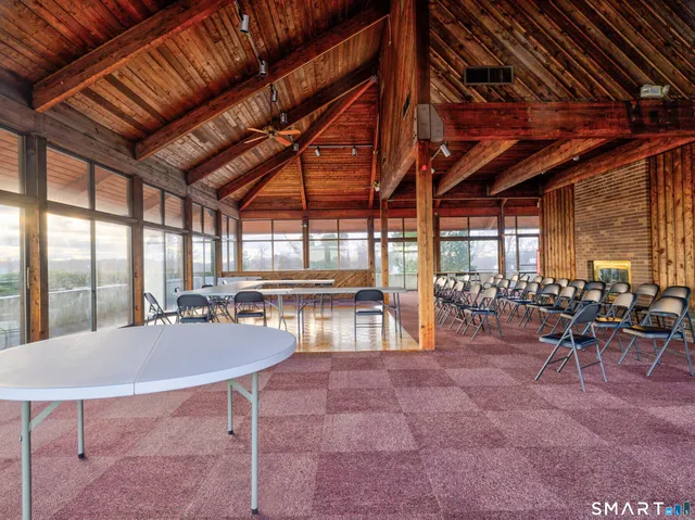 a outdoor space with lots of tables a large window and chairs