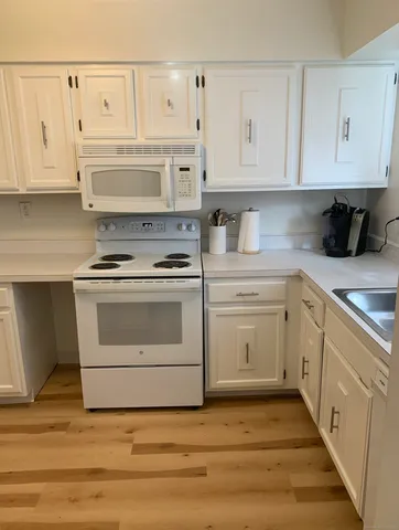 a kitchen with white cabinets and white appliances