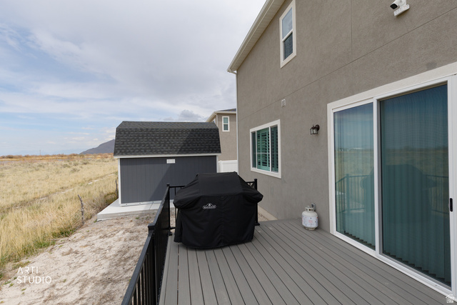 540 Lefty Lane Tooele, UT 84074 - Photo 27 of 48 Wooden deck with area for grilling, a storage unit, and a mountain view