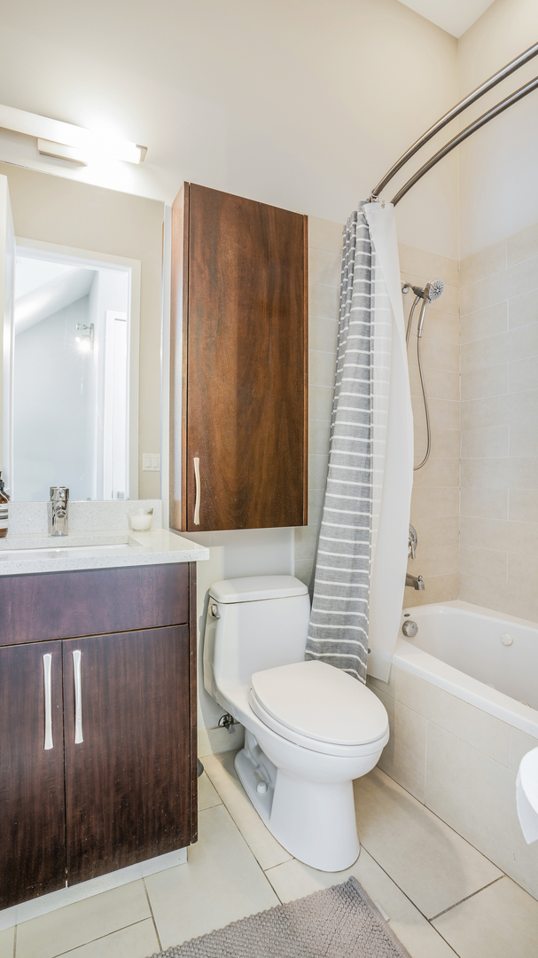 2133 West Rice Street, Unit 3 Chicago, IL 60622 - Photo 16 of 24 a bathroom with a granite countertop toilet sink and mirror