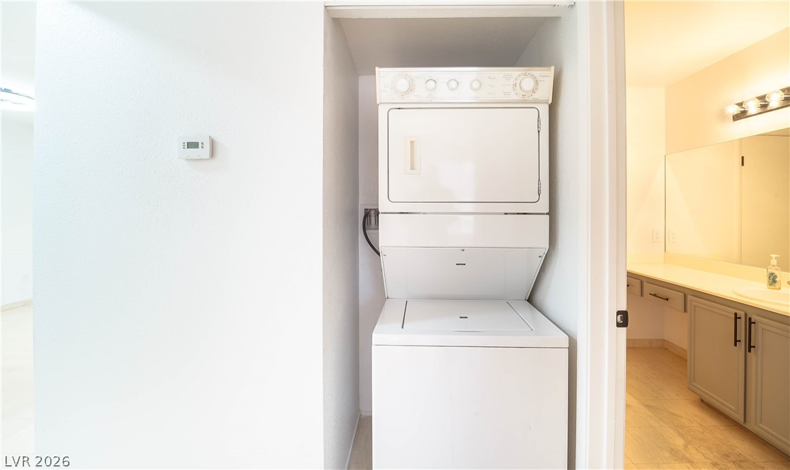 8070 West Russell Road, Unit 1099 Las Vegas, NV 89113 - Photo 21 of 31 A convenient stacked washer and dryer unit occupies a dedicated laundry alcove, adjacent to a well-appointed bathroom.