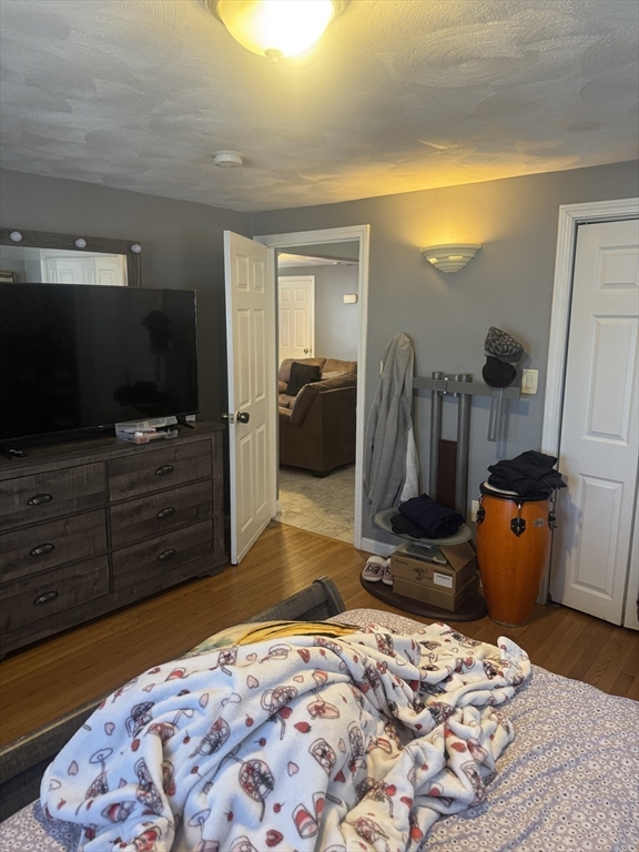 21 Cook, Unit 1 Chelsea, MA 02150 - Photo 14 of 32 a bedroom with a bed and wooden floor