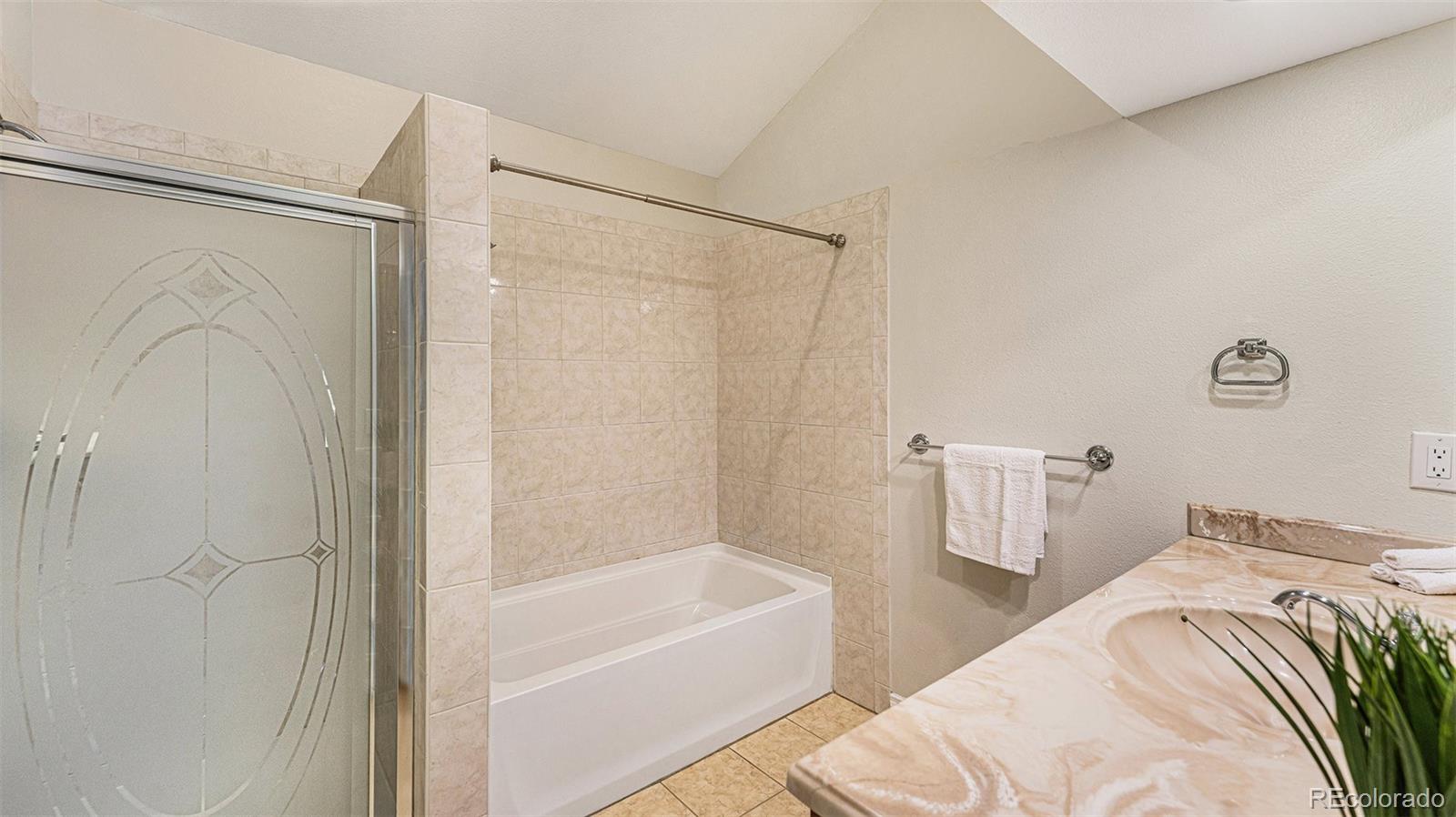 9897 Independence Street Westminster, CO 80021 - Photo 14 of 29 a bathroom with a bathtub and a shower