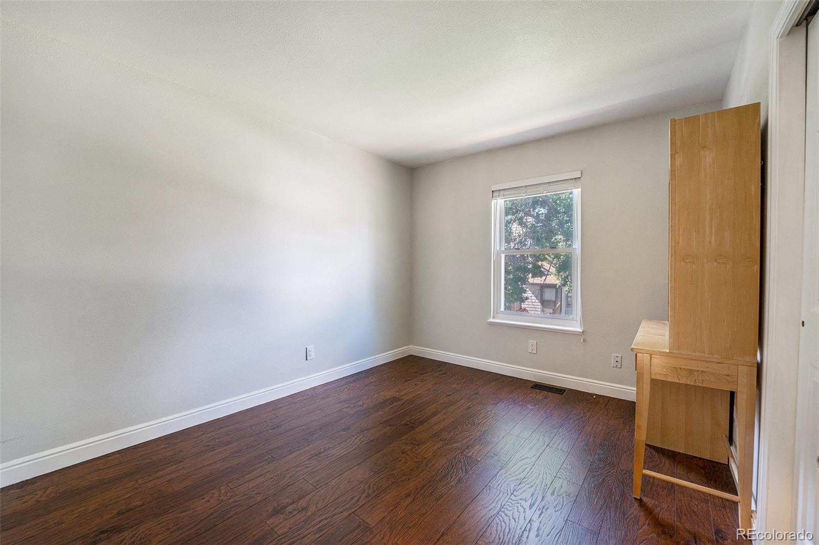 9897 Independence Street Westminster, CO 80021 - Photo 15 of 29 a view of an empty room with wooden floor and a window