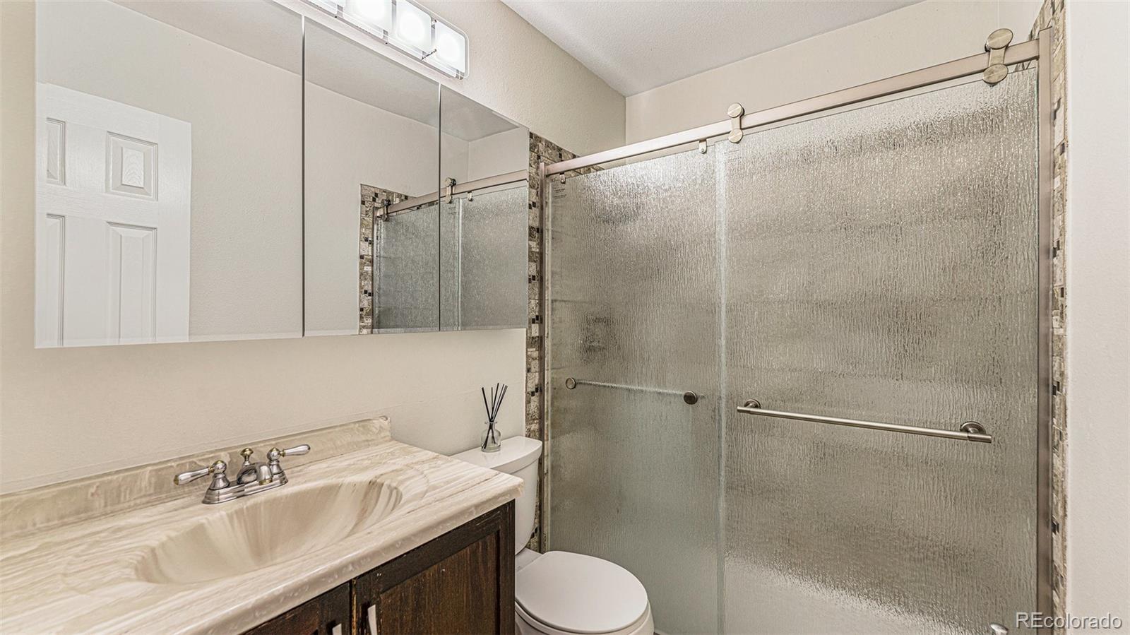 9897 Independence Street Westminster, CO 80021 - Photo 19 of 29 a bathroom with a sink toilet and shower