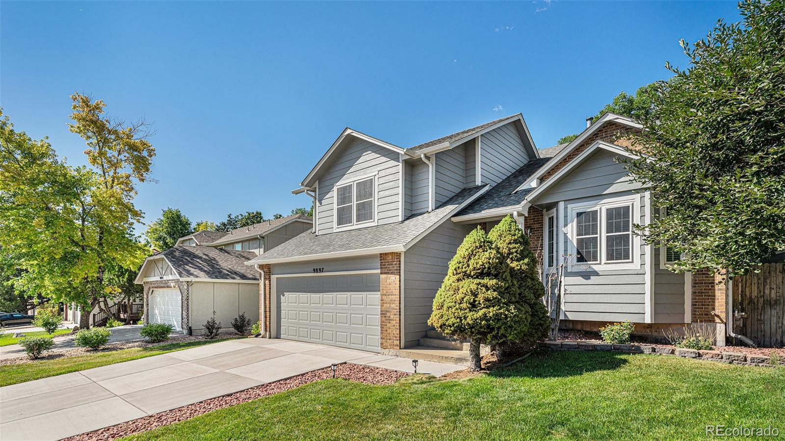 9897 Independence Street Westminster, CO 80021 - Photo 2 of 29 a front view of a house with a garden