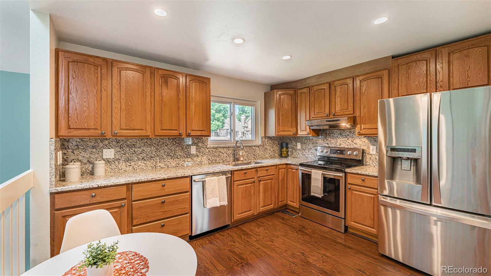 9897 Independence Street Westminster, CO 80021 - Photo 7 of 29 a kitchen with granite countertop stainless steel appliances a refrigerator sink and microwave