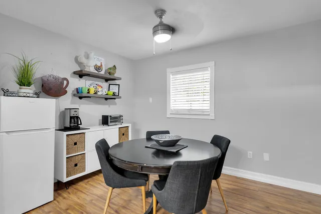 a kitchen with a dining table chairs and refrigerator