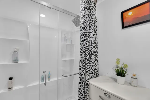 a bathroom with a sink a toilet and shower