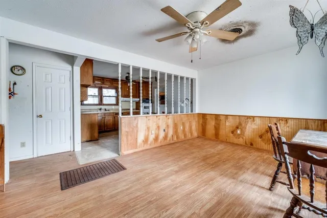 a view of a large room with wooden floor and windows