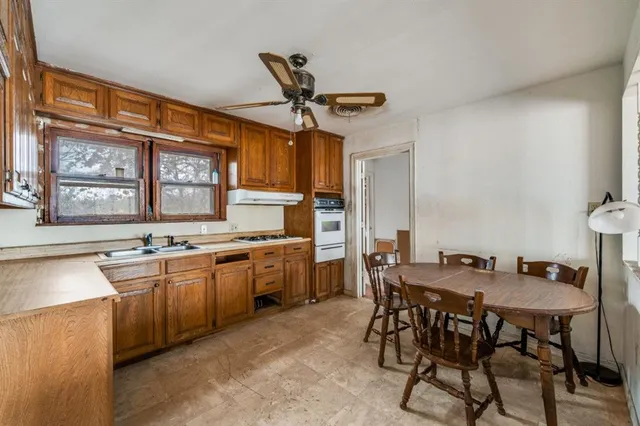 a kitchen with a table chairs stove and cabinets