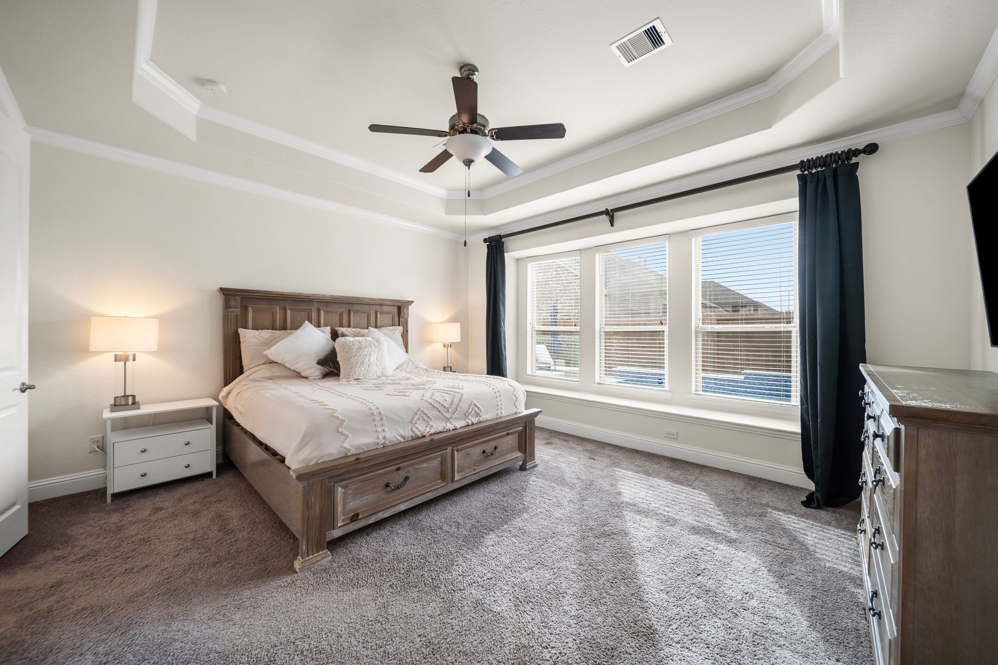 18307 Whistling Hills Road Cypress, TX 77433 - Photo 8 of 38 The primary suite is anything but builder-grade, showcasing tray ceilings, expansive windows with backyard views, and a tranquil feel throughout. Double doors lead to a spa-inspired bath with a soaking tub, dual sinks, and an oversized walk-in closet.