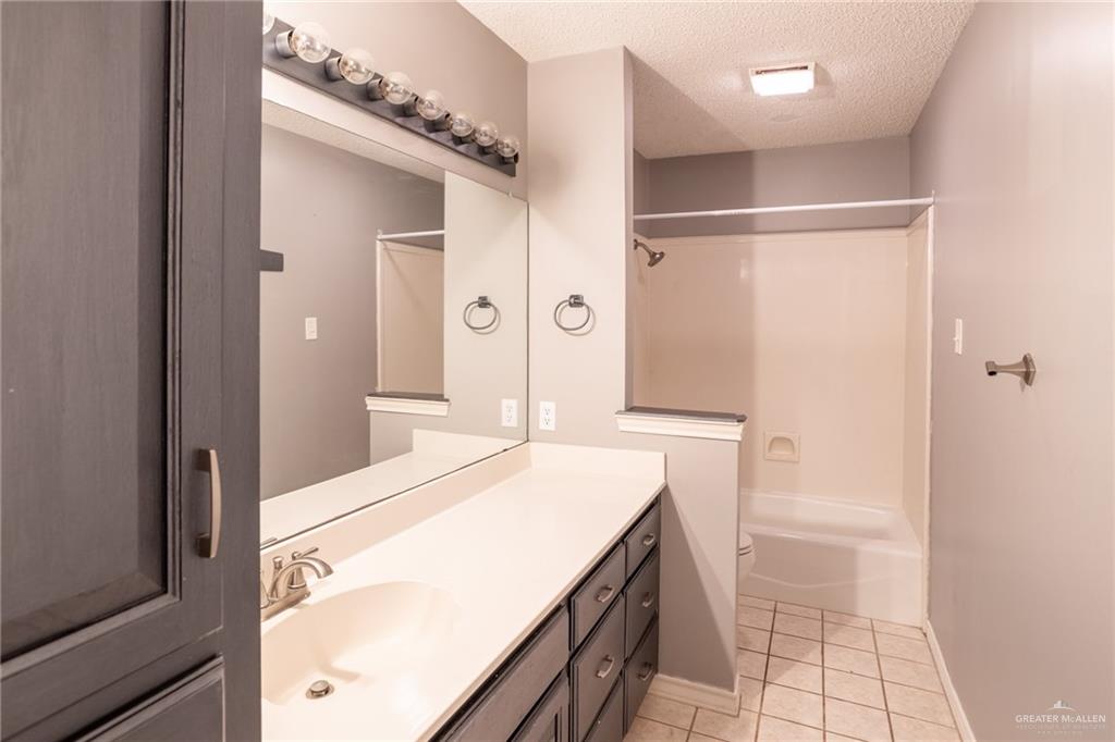 7434 Lake Como Drive Corpus Christi, TX 78413 - Photo 15 of 20 Full bathroom featuring vanity, tile patterned floors, washtub / shower combination, toilet, and a textured ceiling