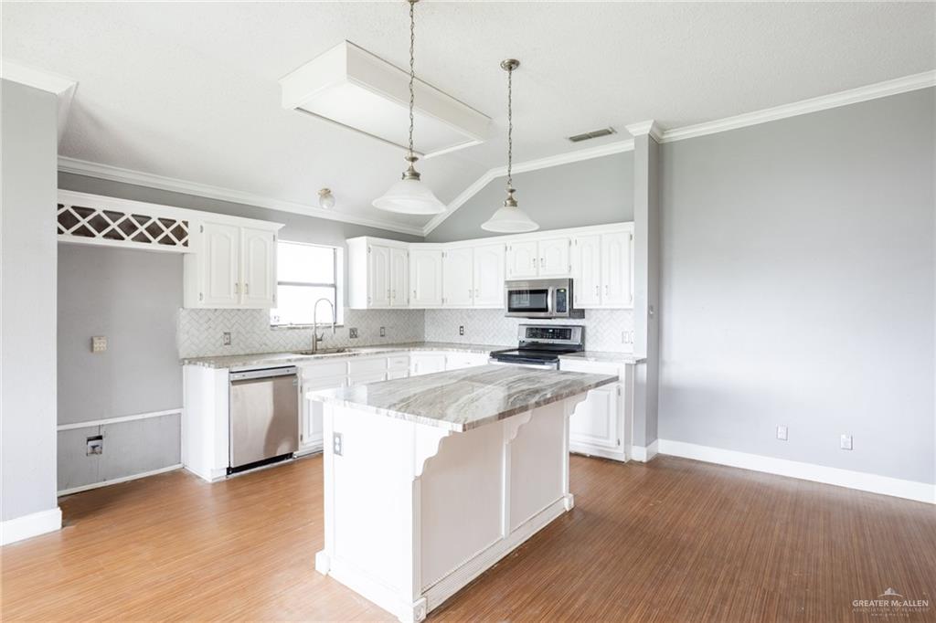 7434 Lake Como Drive Corpus Christi, TX 78413 - Photo 5 of 20 Kitchen featuring appliances with stainless steel finishes, white cabinetry, and a kitchen island