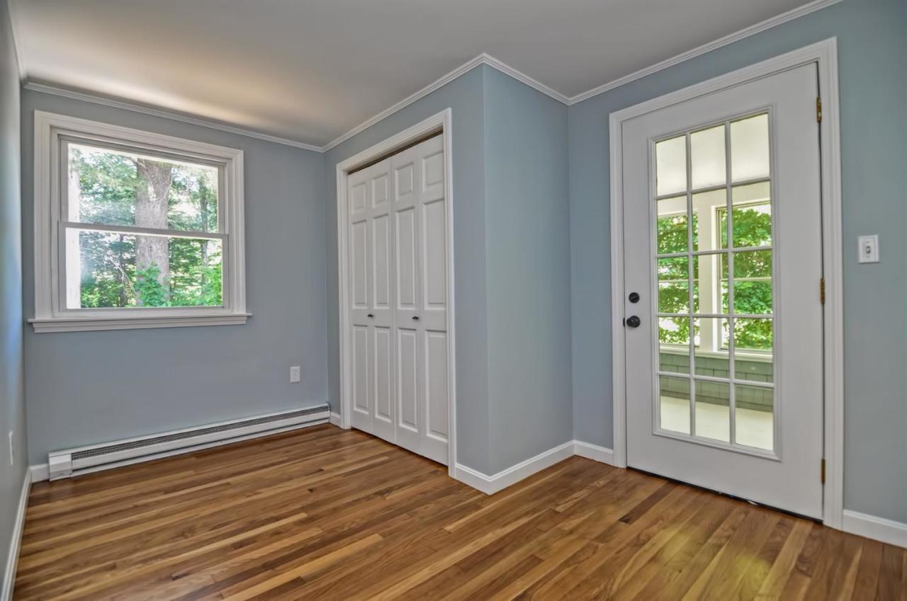 56 Elgin Road Pocasset, MA 02559 - Photo 16 of 35 a view of an empty room with wooden floor and a window