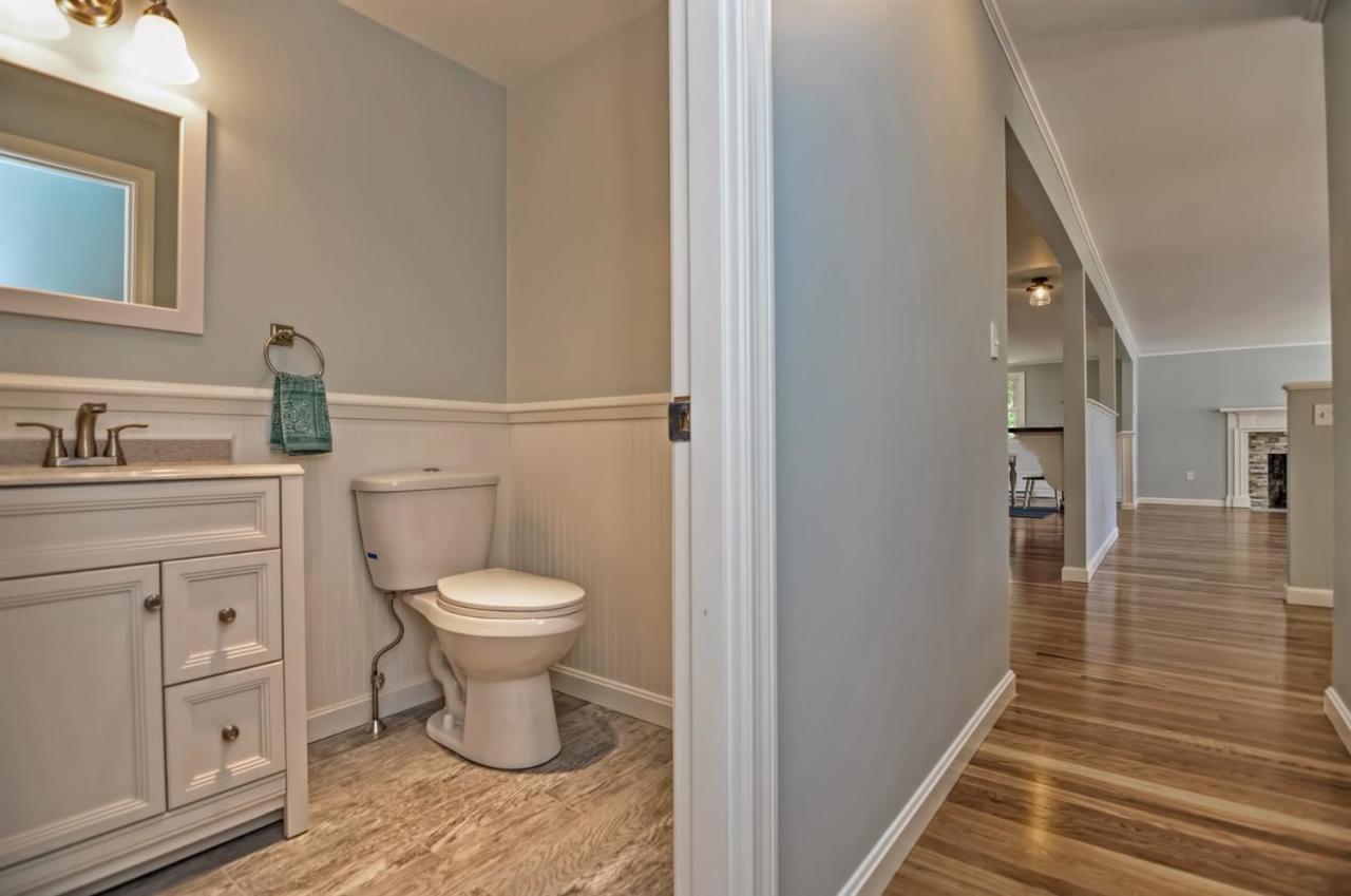 56 Elgin Road Pocasset, MA 02559 - Photo 19 of 35 a bathroom with a toilet a sink and wooden floor
