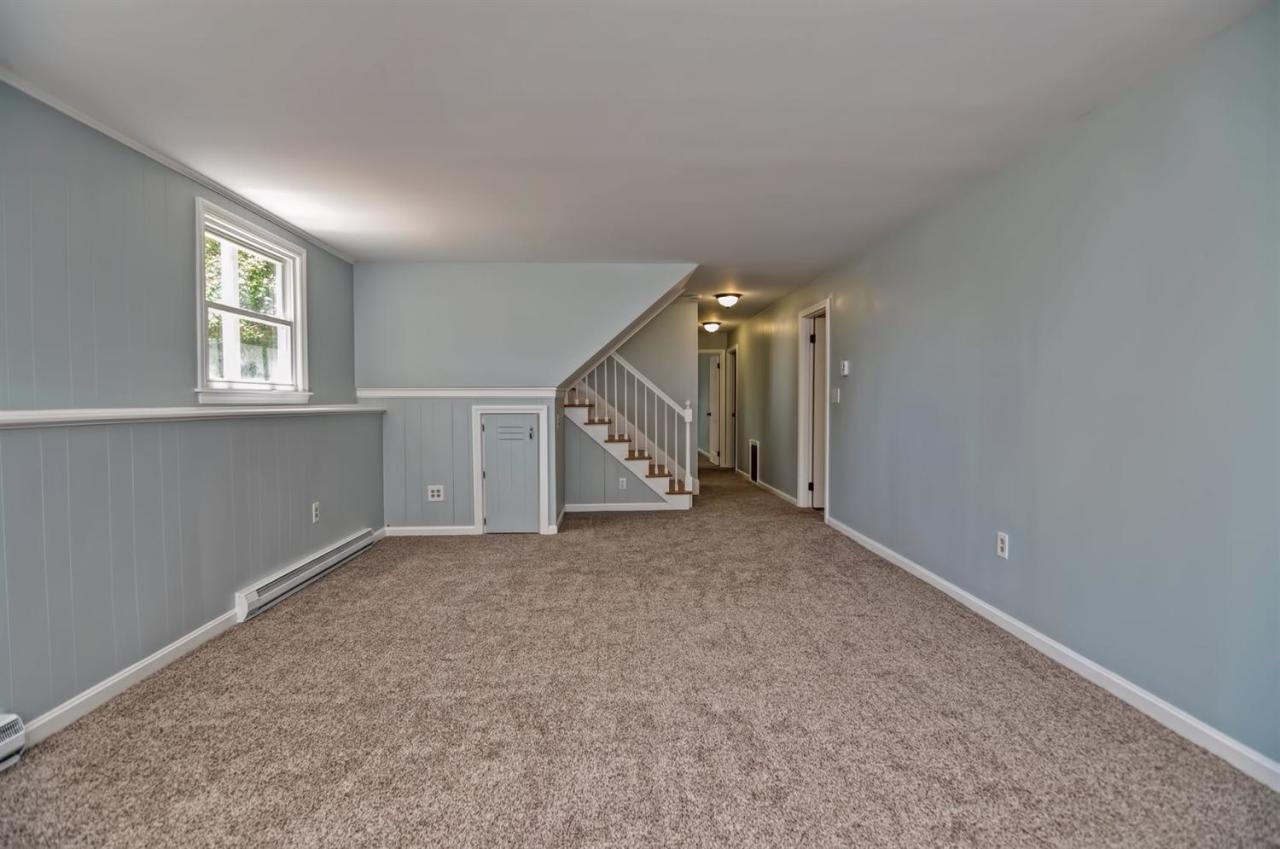 56 Elgin Road Pocasset, MA 02559 - Photo 24 of 35 an empty room with windows and stairs