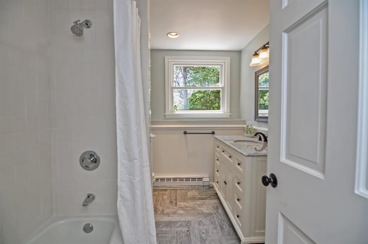 56 Elgin Road Pocasset, MA 02559 - Photo 25 of 35 a bathroom with a tub sink and mirror