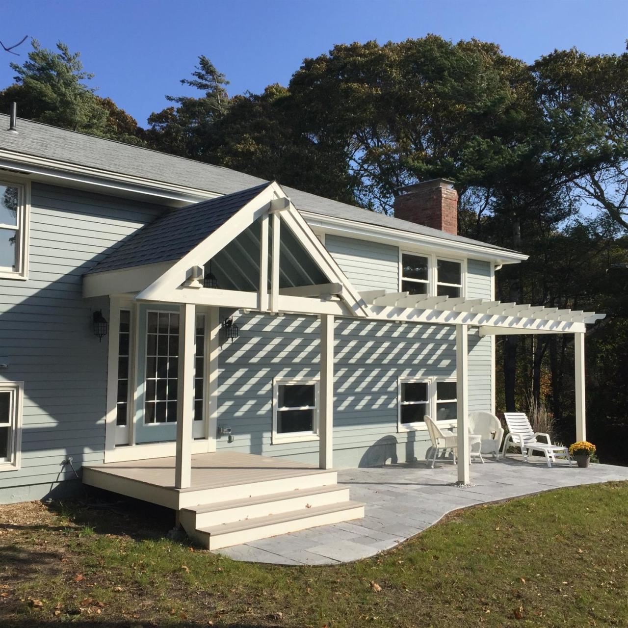 56 Elgin Road Pocasset, MA 02559 - Photo 4 of 35 a front view of a house with a yard table and chairs