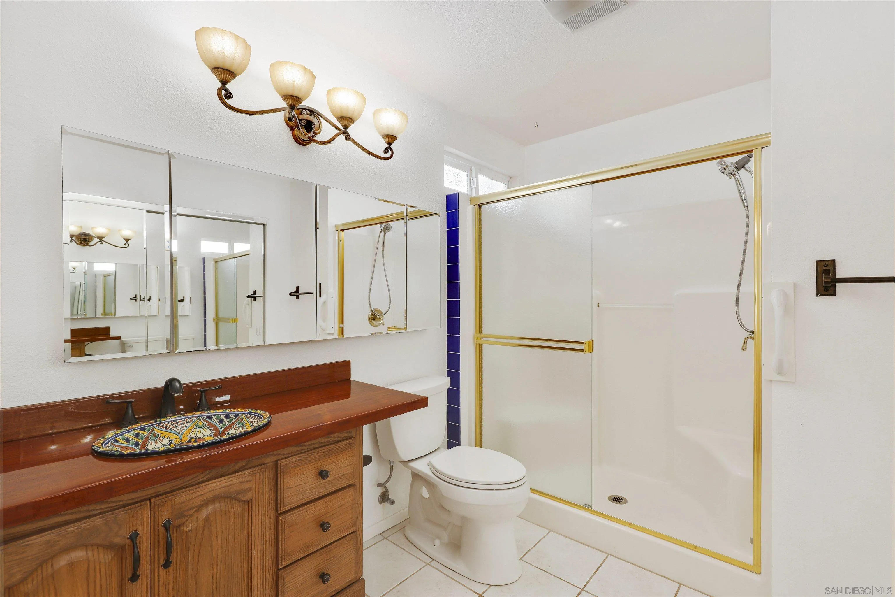 4716 Sunrise Ridge Oceanside, CA 92056 - Photo 20 of 31 a bathroom with a granite countertop sink a toilet a mirror and shower