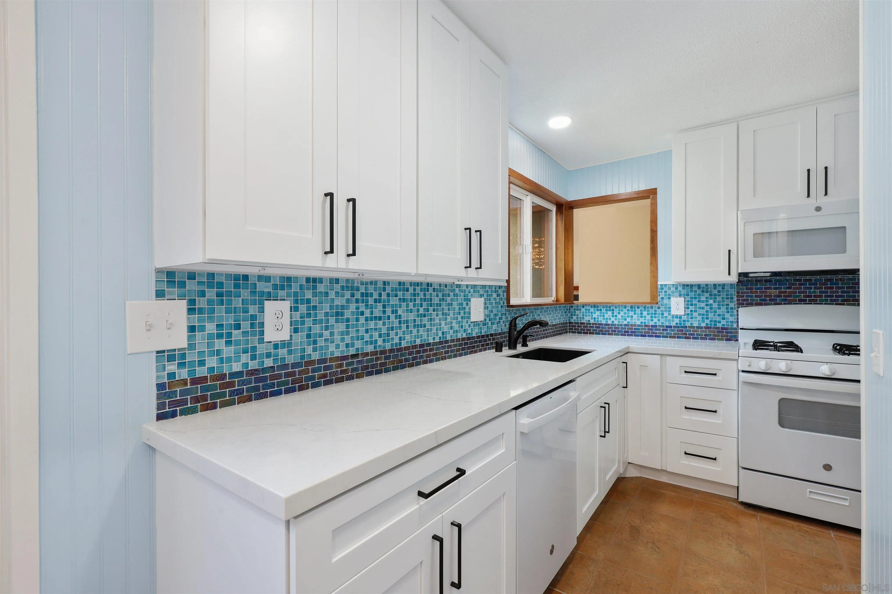 4716 Sunrise Ridge Oceanside, CA 92056 - Photo 3 of 31 a kitchen with granite countertop white cabinets and white appliances