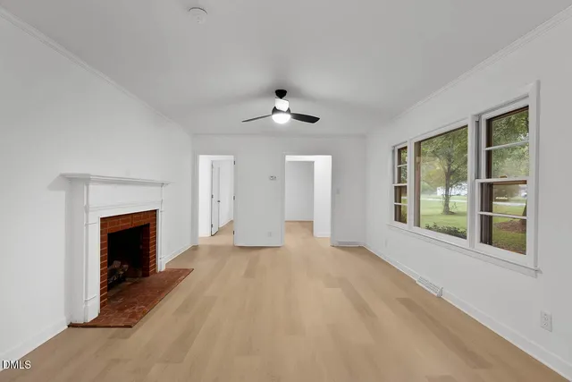 a view of an empty room with a fireplace and a window